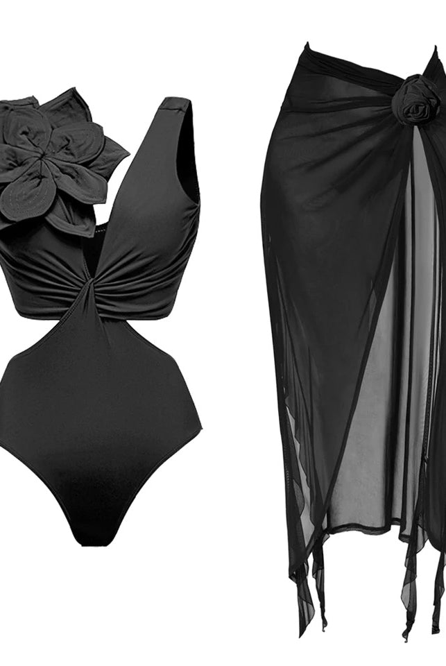 Black swimsuit with cut out side detailing & a 3d black large flower applique featured on the shoulder. Matched with a black mesh rose corsarge detailed on  midi- maxi beach skirt 
