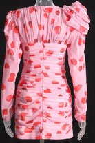 Polka dot print ruched mini dress featuring a rose corsage on the shoulder and front cut out. The dress is lined and has a zip fasten on the back. This chiffon print is red and pink..